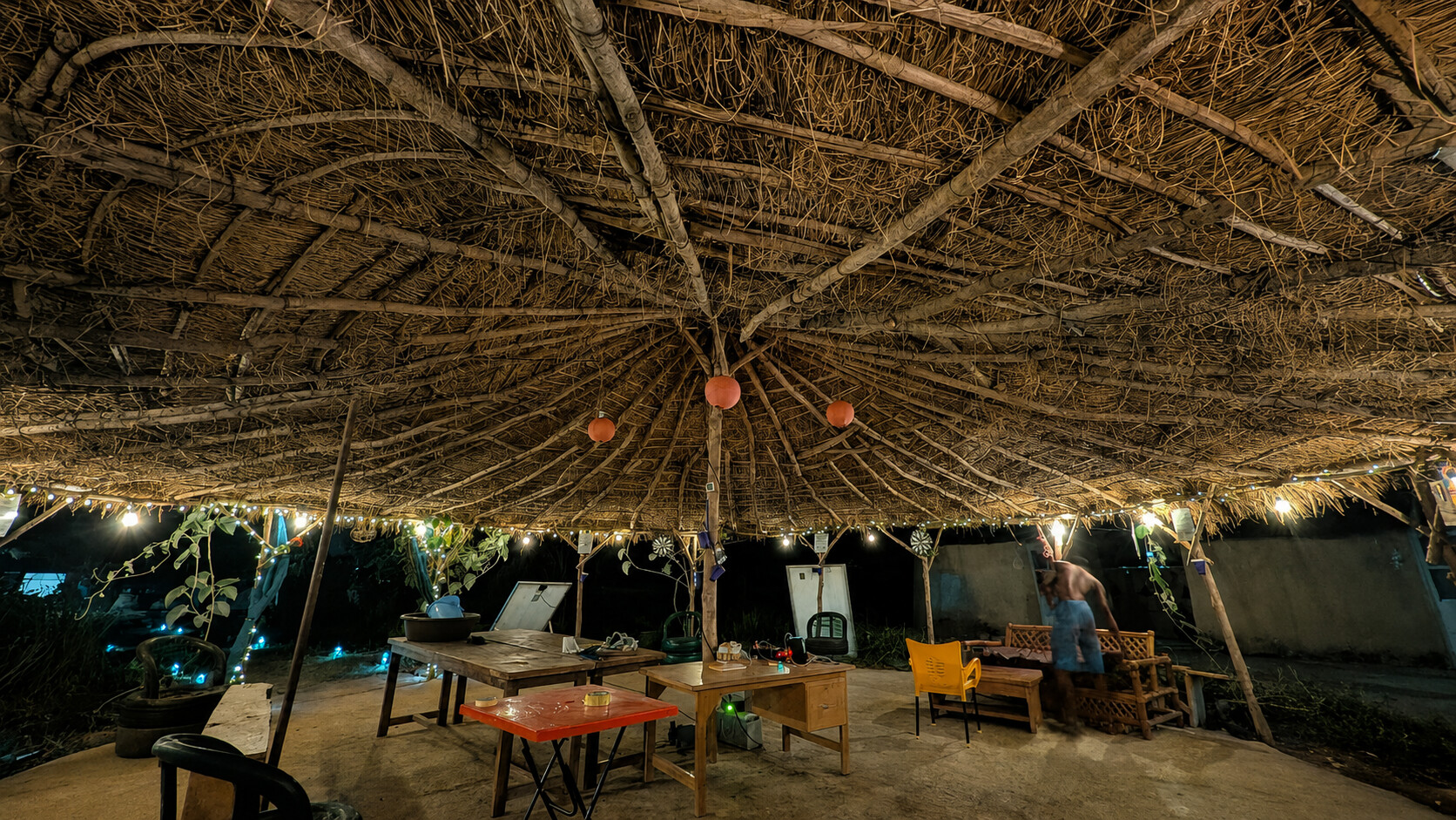 The illuminated thatched pavilion at Dream Village in the evening